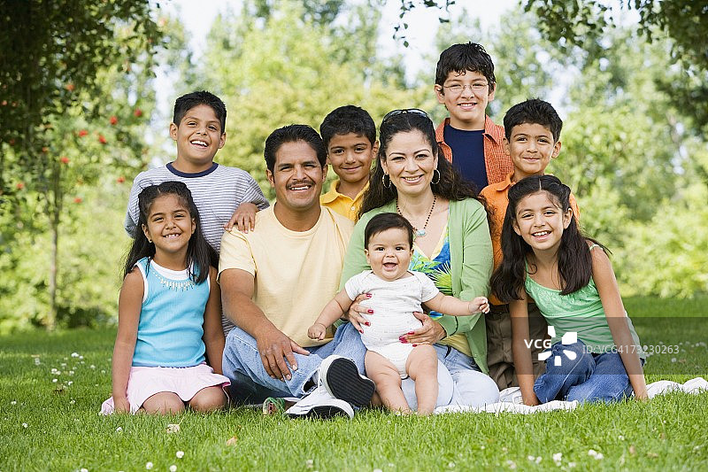 西班牙裔家庭坐在户外微笑着图片素材