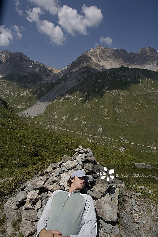 少年在法国阿尔卑斯山瓦努瓦兹国家公园的岩石堆上小憩图片素材