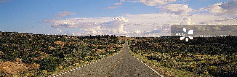 美国新墨西哥州奇马约附近，通往地平线的铺砌道路图片素材