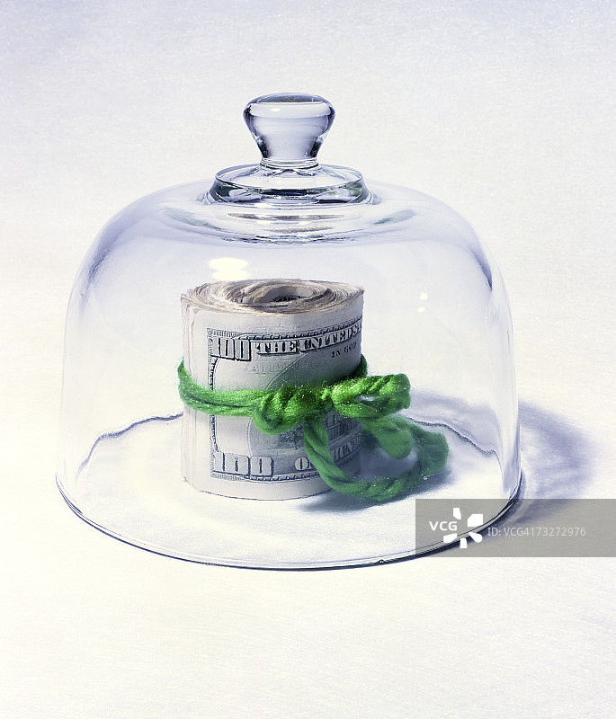 玻璃罩下的纸币卷图片素材