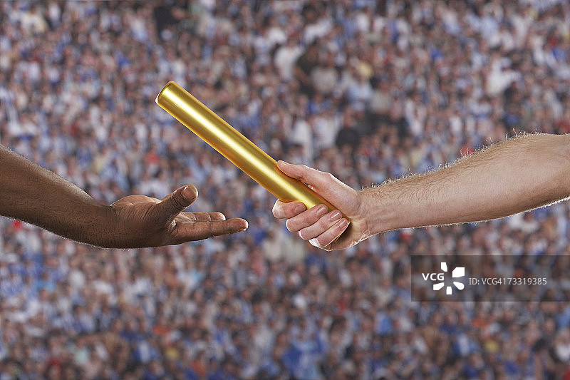 两名男子传递接力棒，手部特写图片素材