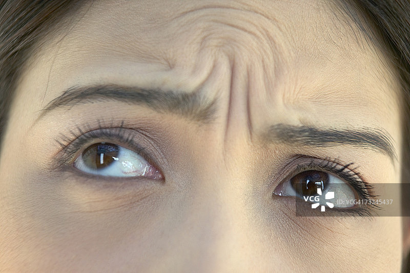 眉间有皱纹的女人，高角度拍摄，眼睛特写图片素材