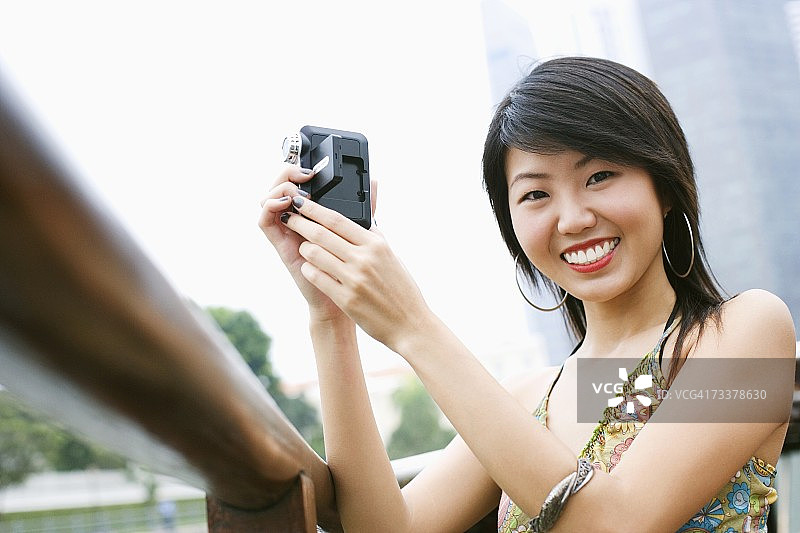 年轻女子手持家用摄像机的肖像图片素材