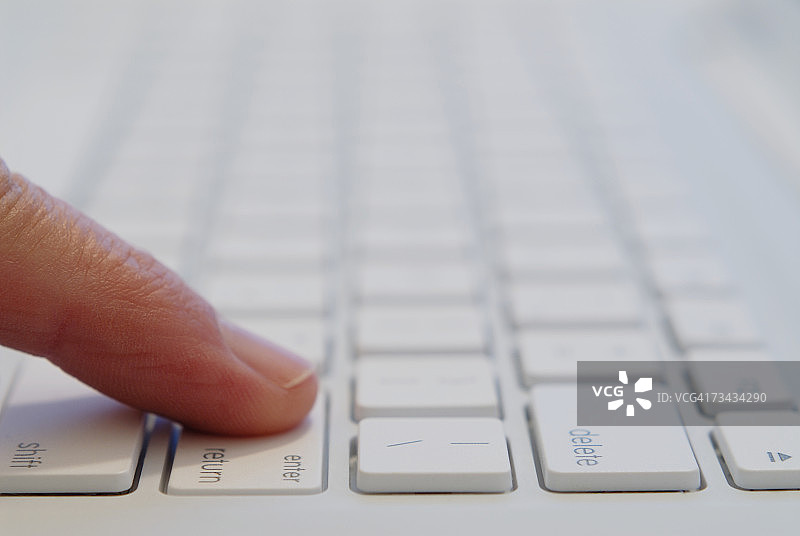 特写：在电脑键盘上按回车键的人图片素材