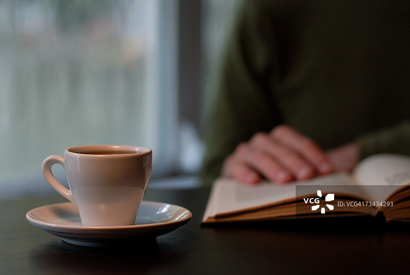 男人在咖啡旁看书，特写图片素材