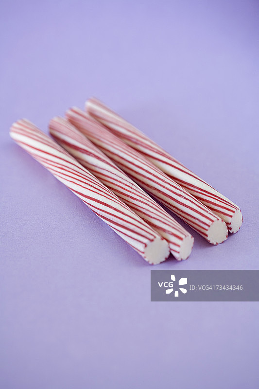 紫色背景上的四根薄荷糖图片素材