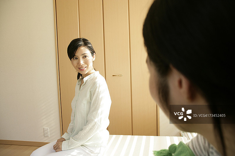中年妇女和她的女儿坐在床上图片素材
