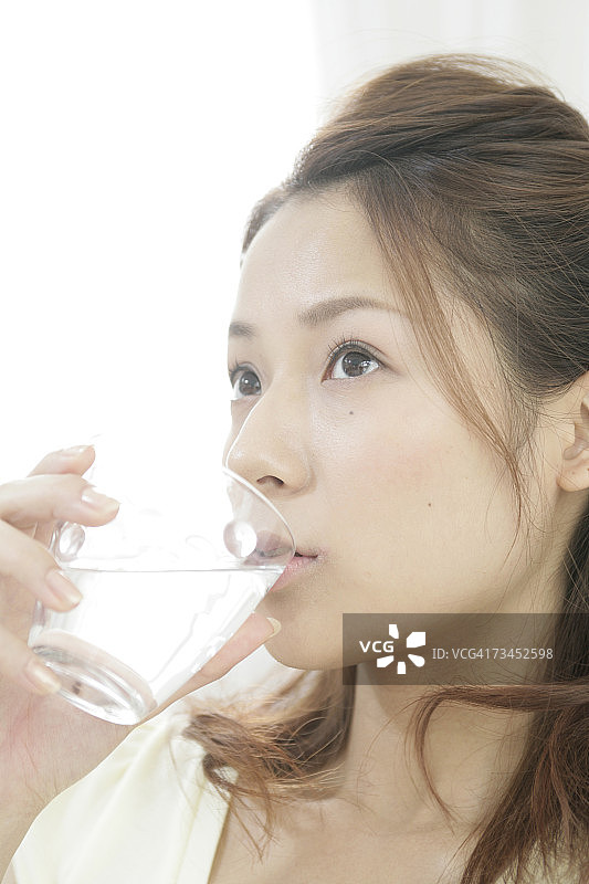 年轻女人喝一杯水的特写图片素材