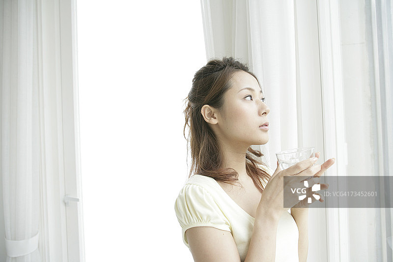手持玻璃杯的年轻女子特写图片素材