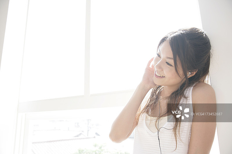 年轻女子听音乐面露喜色特写图片素材