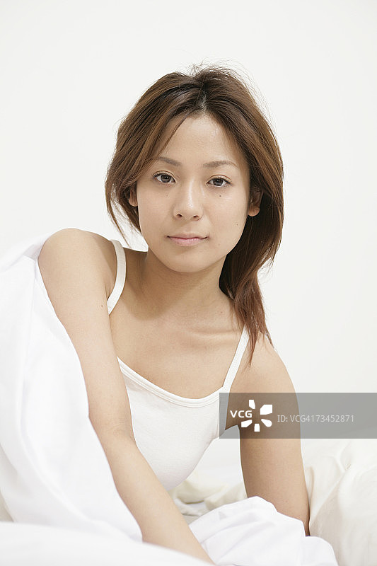 年轻女子斜躺在床上的肖像图片素材