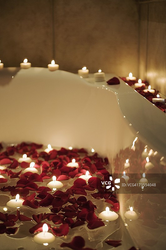 浴缸中蜡烛和玫瑰花瓣的浪漫场景图片素材