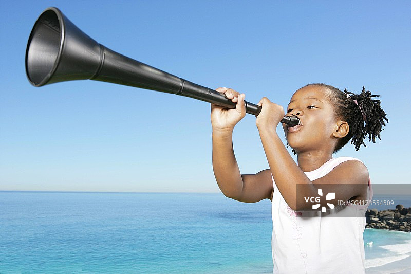 吹着呜呜祖拉的年轻非洲女孩图片素材