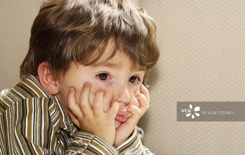 男孩手放在脸颊上躺下图片素材