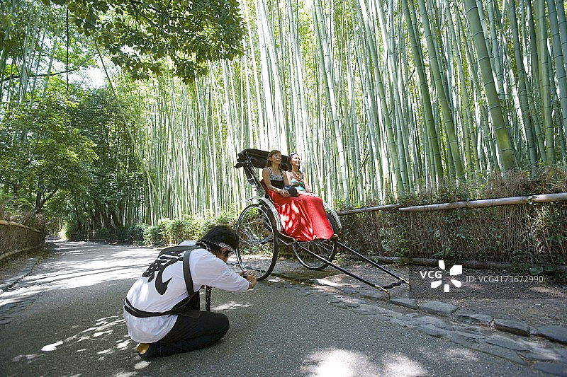 两位年轻女人坐在日本京都嵯峨野的人力车上图片素材