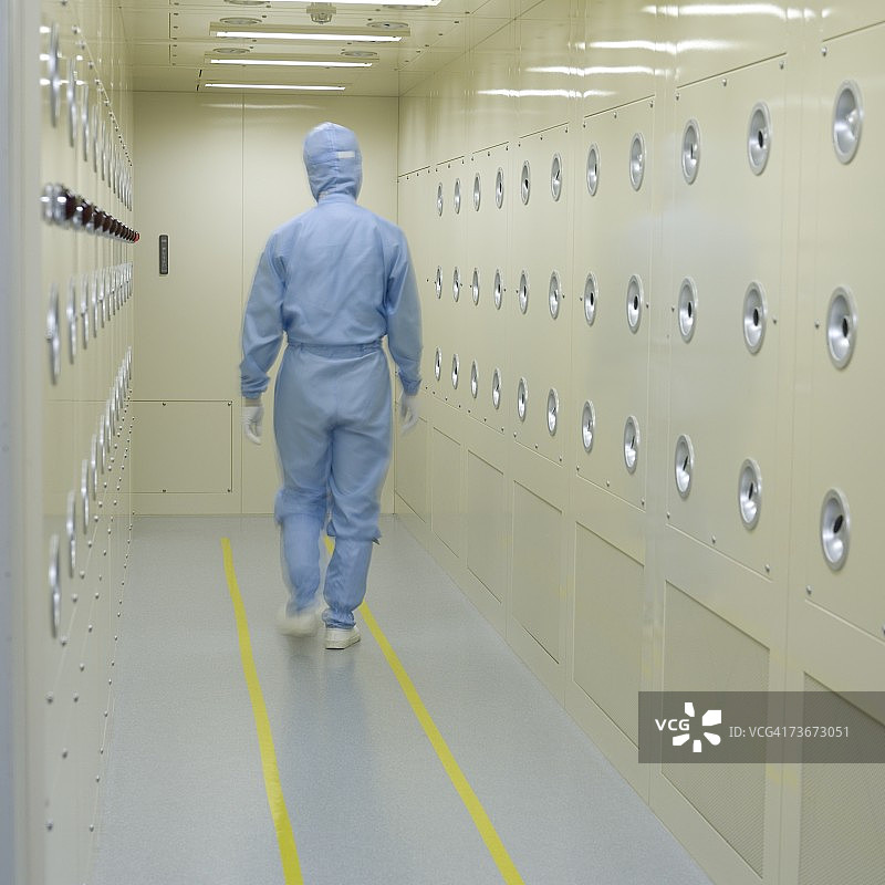 穿着干净西装走在走廊上的男人的背影图片素材