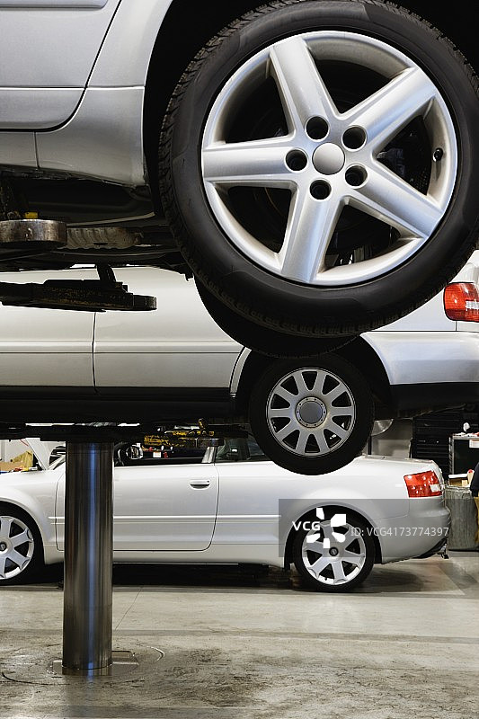 汽车修理店的液压升降机上的车辆图片素材