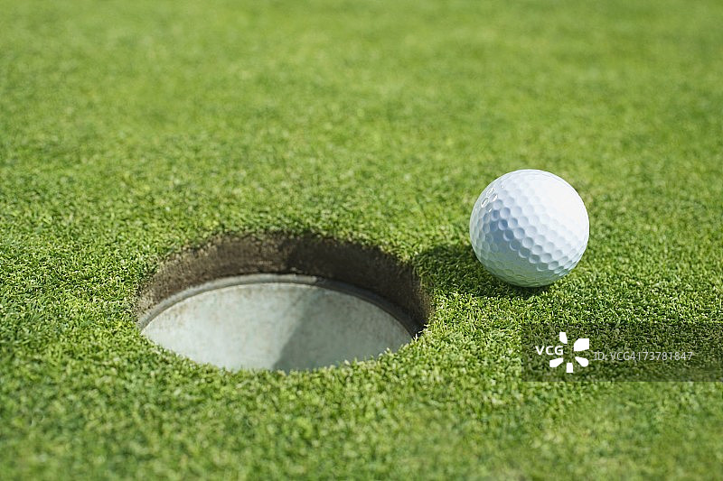 户外果岭球洞旁的高尔夫球图片素材