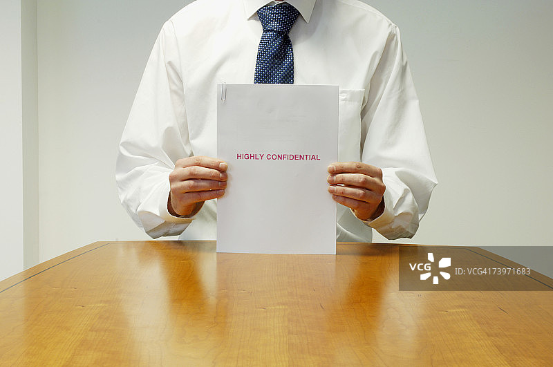 行政人员在办公桌前拿着机密文件细节图片素材