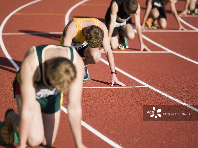 一群男运动员在跑道上的起跑线上图片素材