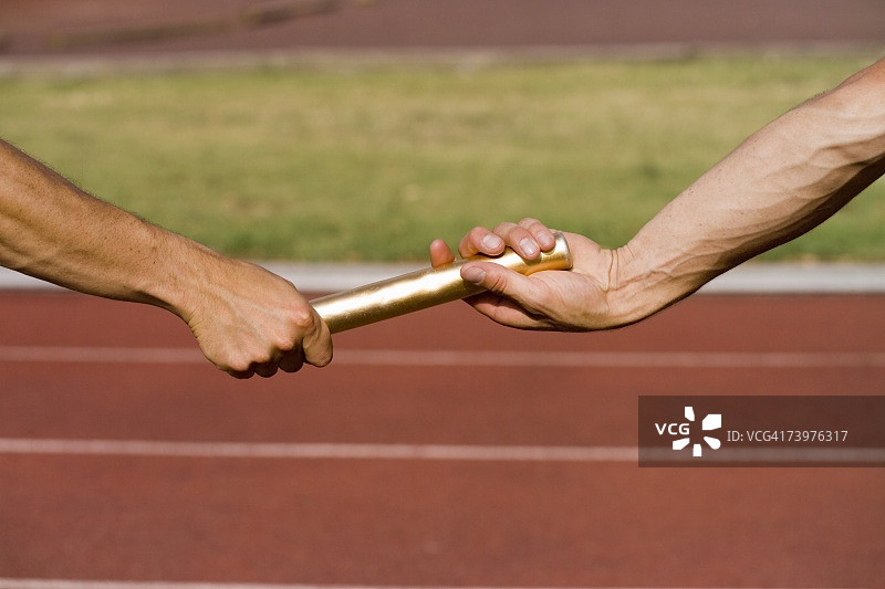 两名运动员在接力赛中交换接力棒图片素材