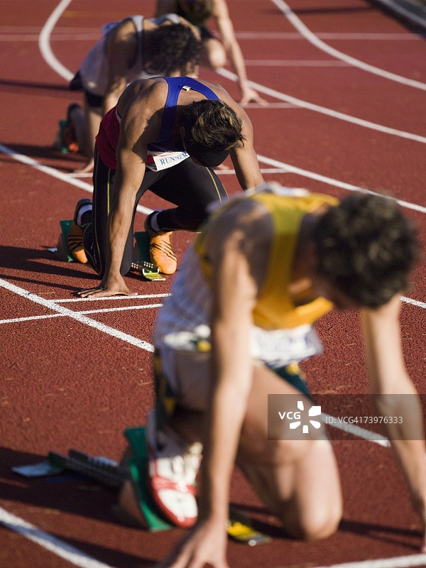 一群男运动员在跑道上的起跑线上图片素材