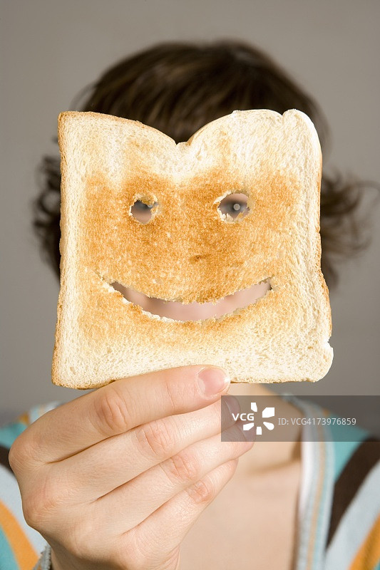 手拿吐司挡住脸的女人图片素材