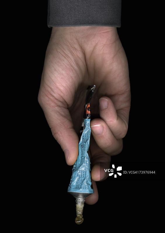 男人拿着一管胶水图片素材