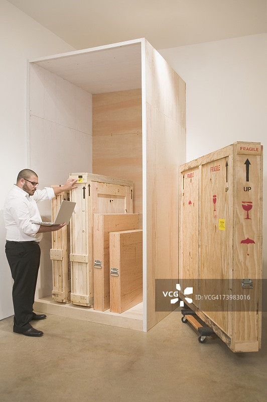 艺术品商人使用笔记本电脑跟踪货物运输图片素材