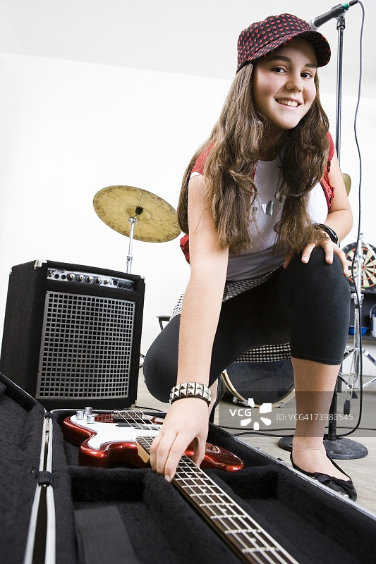 少女伸手去拿贝斯吉他图片素材