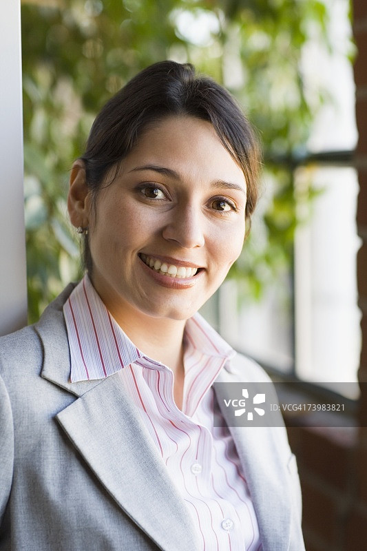 在办公室窗边的年轻职业女性图片素材