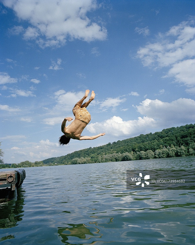 年轻男子在湖中翻跟头图片素材