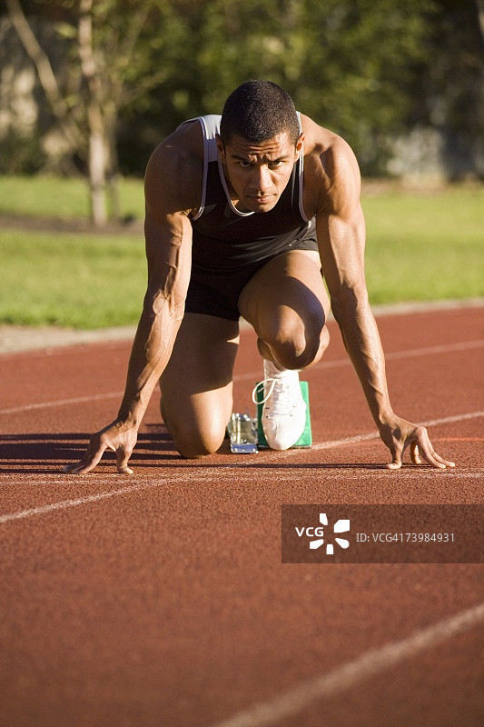 在跑道起跑器上的男运动员图片素材