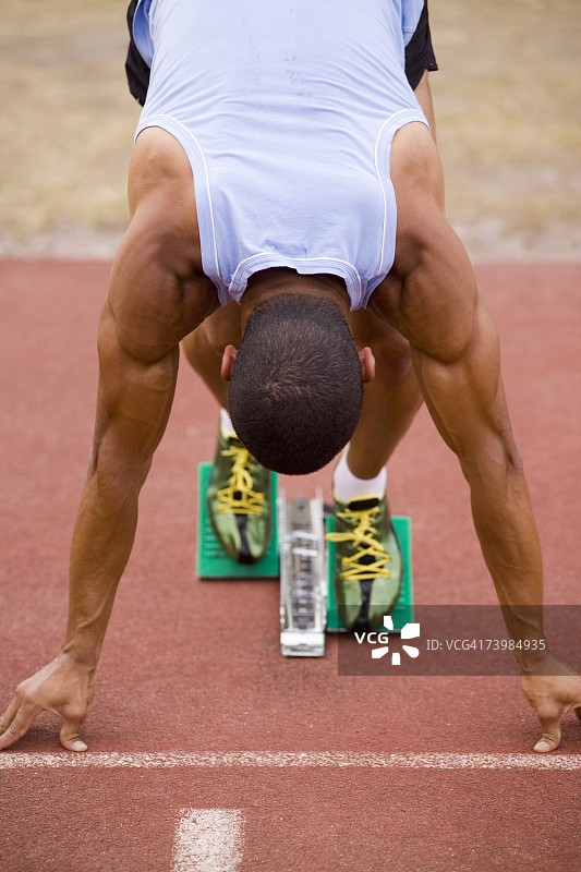 在跑道起跑器上的男运动员图片素材