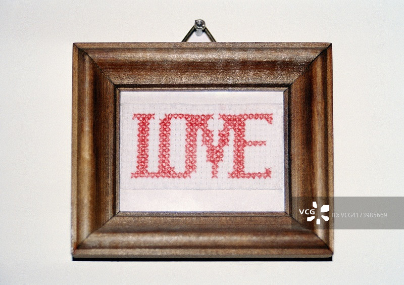墙上悬挂的爱心十字绣图片素材
