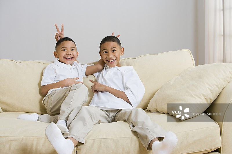 印度兄弟在沙发上嬉闹图片素材