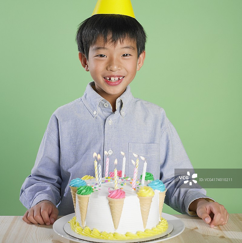 手持生日蛋糕的亚洲男孩肖像图片素材