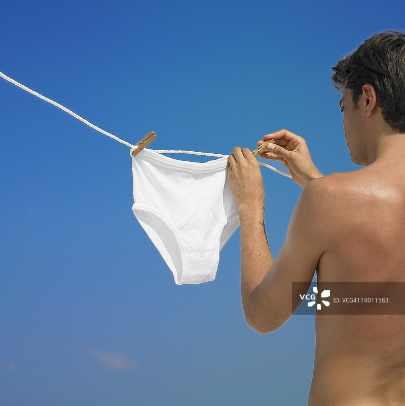 男人在晾衣绳上挂内衣图片素材