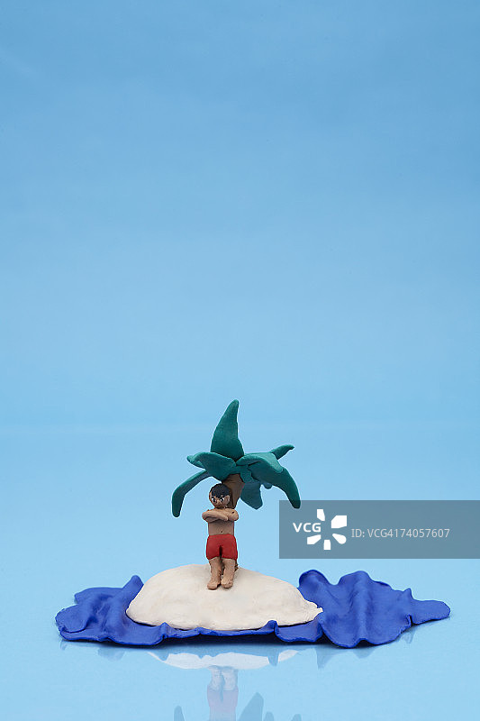 蓝色背景的荒岛上男子黏土模型图片素材