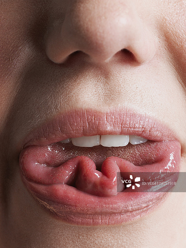 年轻女人卷起舌头，嘴部特写图片素材