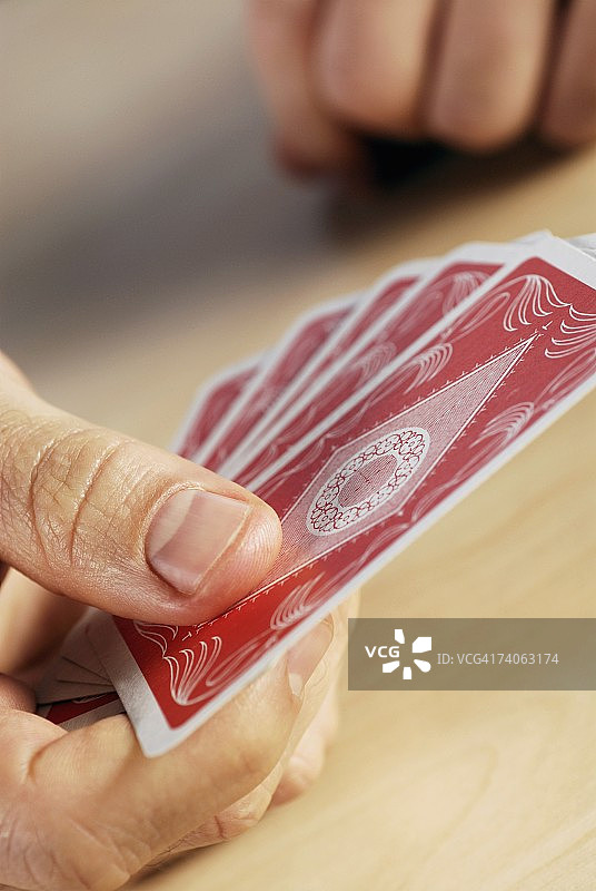 拿着扑克牌的人的手部特写图片素材