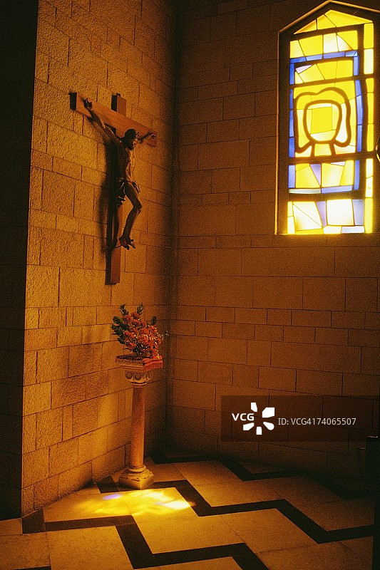 拿撒勒报喜大教堂内墙上的耶稣基督雕像，地板上放着花瓶图片素材