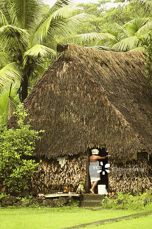 女子站在斐济瓦努阿列雾岛小屋门口的背面视角图片素材