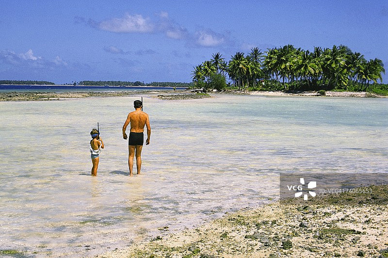 男人和孩子站在海滩上，马朱罗，马绍尔群岛图片素材