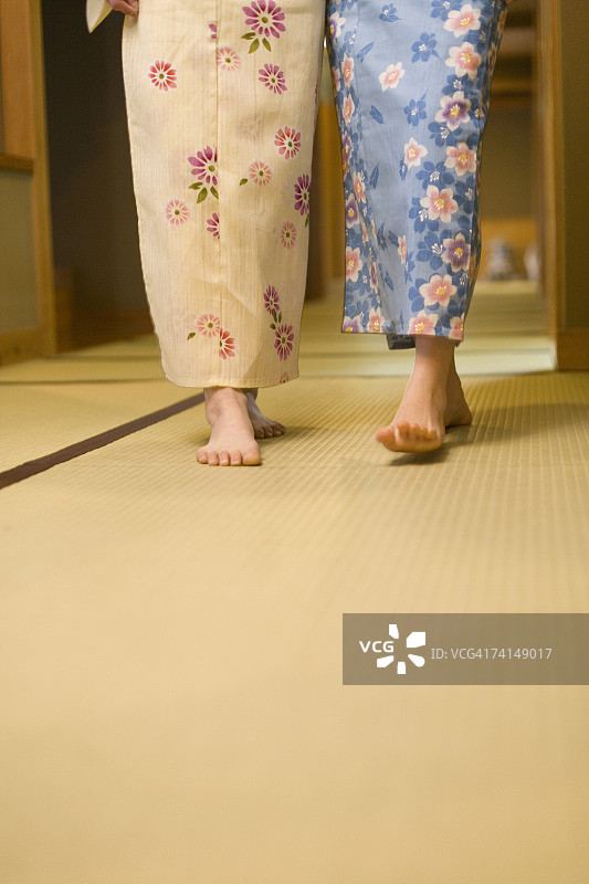 两个女人穿着浴衣走在榻榻米上，正面视角，留白，日本图片素材