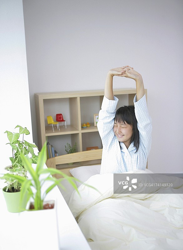 早上在床上伸展的日本女性图片素材