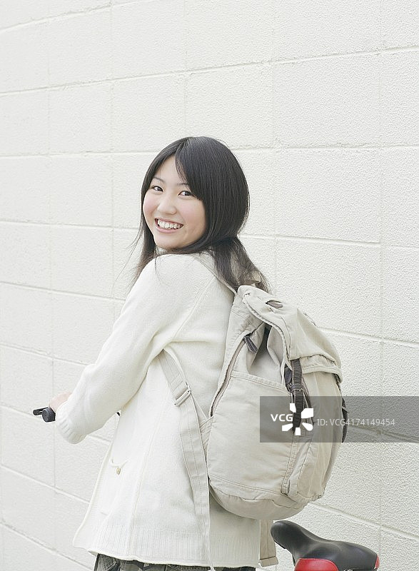 面带微笑骑自行车的日本年轻女子肖像图片素材