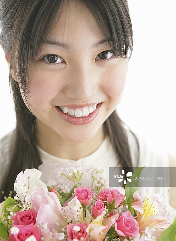 手持花束的日本年轻女子肖像图片素材