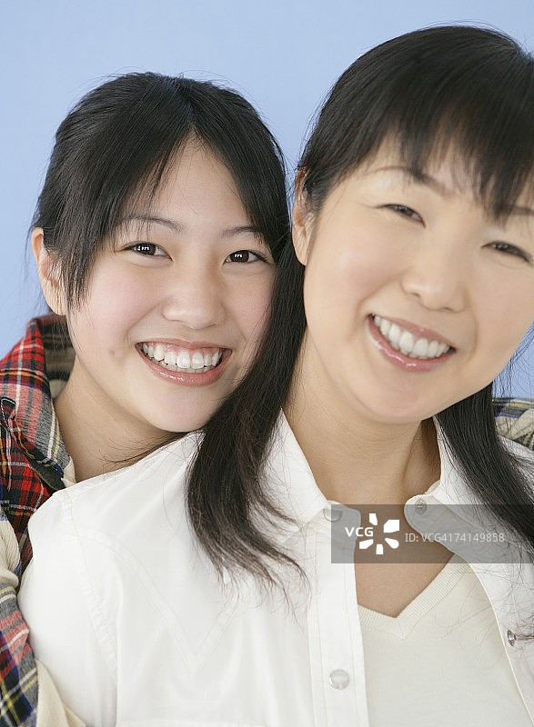 日本年轻女子和成年女子微笑看着镜头图片素材
