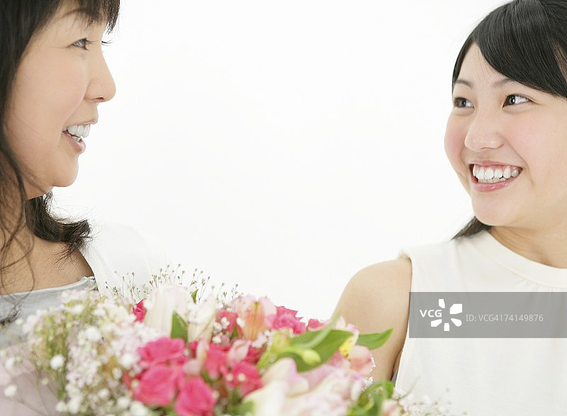 日本年轻女子给母亲送花，面带微笑图片素材